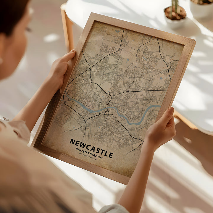 a woman holding a framed map of newcastle