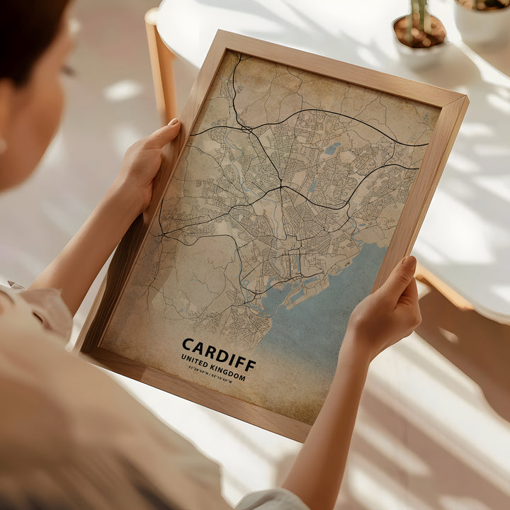 a woman holding a framed map of cardiff