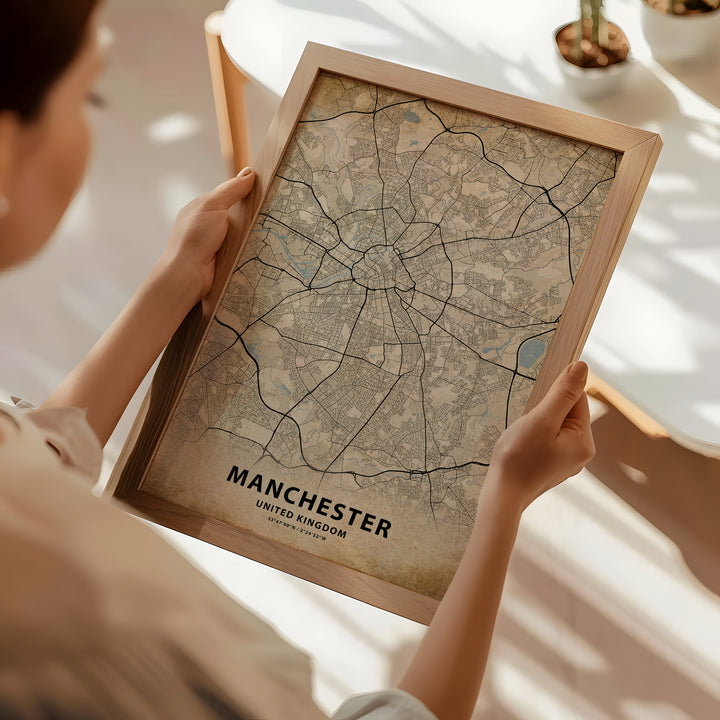 a woman holding a framed map of manchester