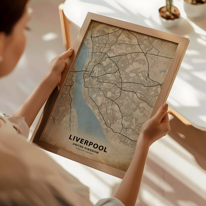 a woman holding a framed map of liverpool